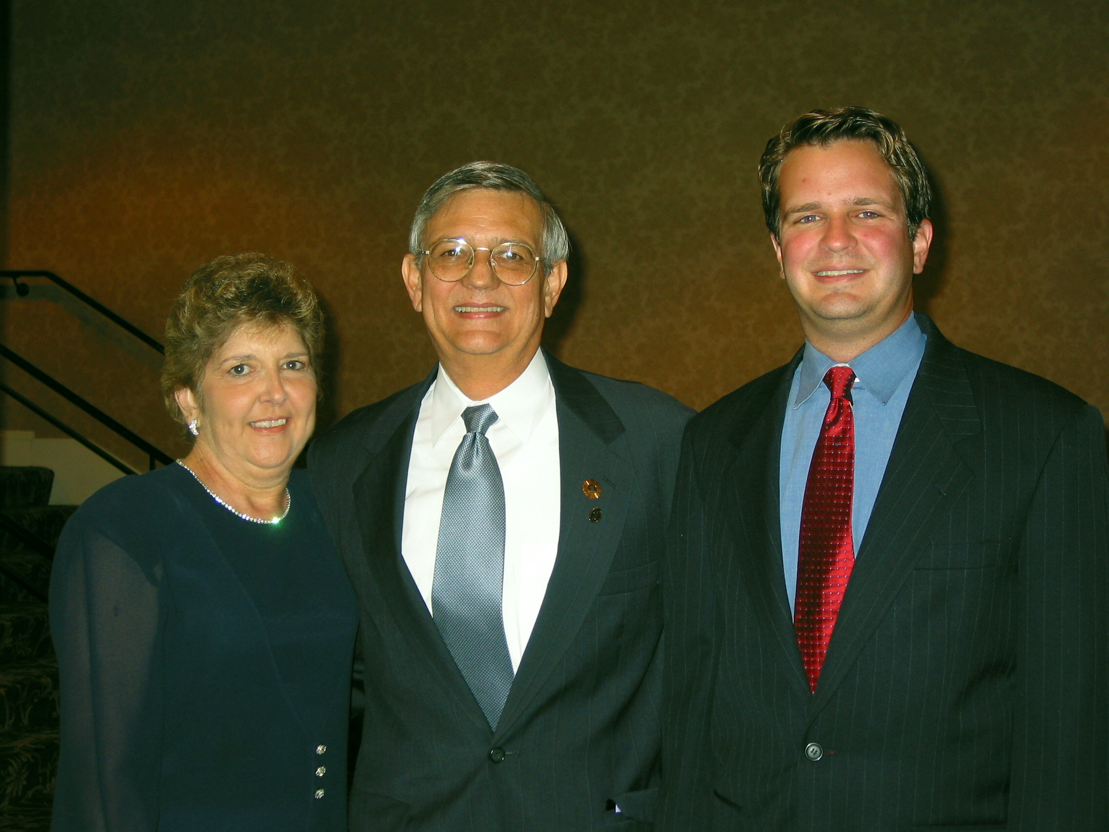 Former Purchasing Director Dick Cummings (center) is pictured at a special reception honoring him for his dedication to NIGP. He is photographed with his wife and son.