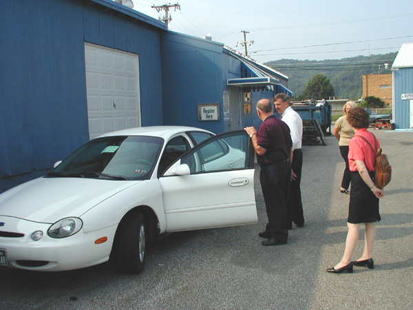 Administration Supervisor Dave White shows Cabinet Secretary Greg Burton a surplus vehicle which was recently retired from a state agency. 